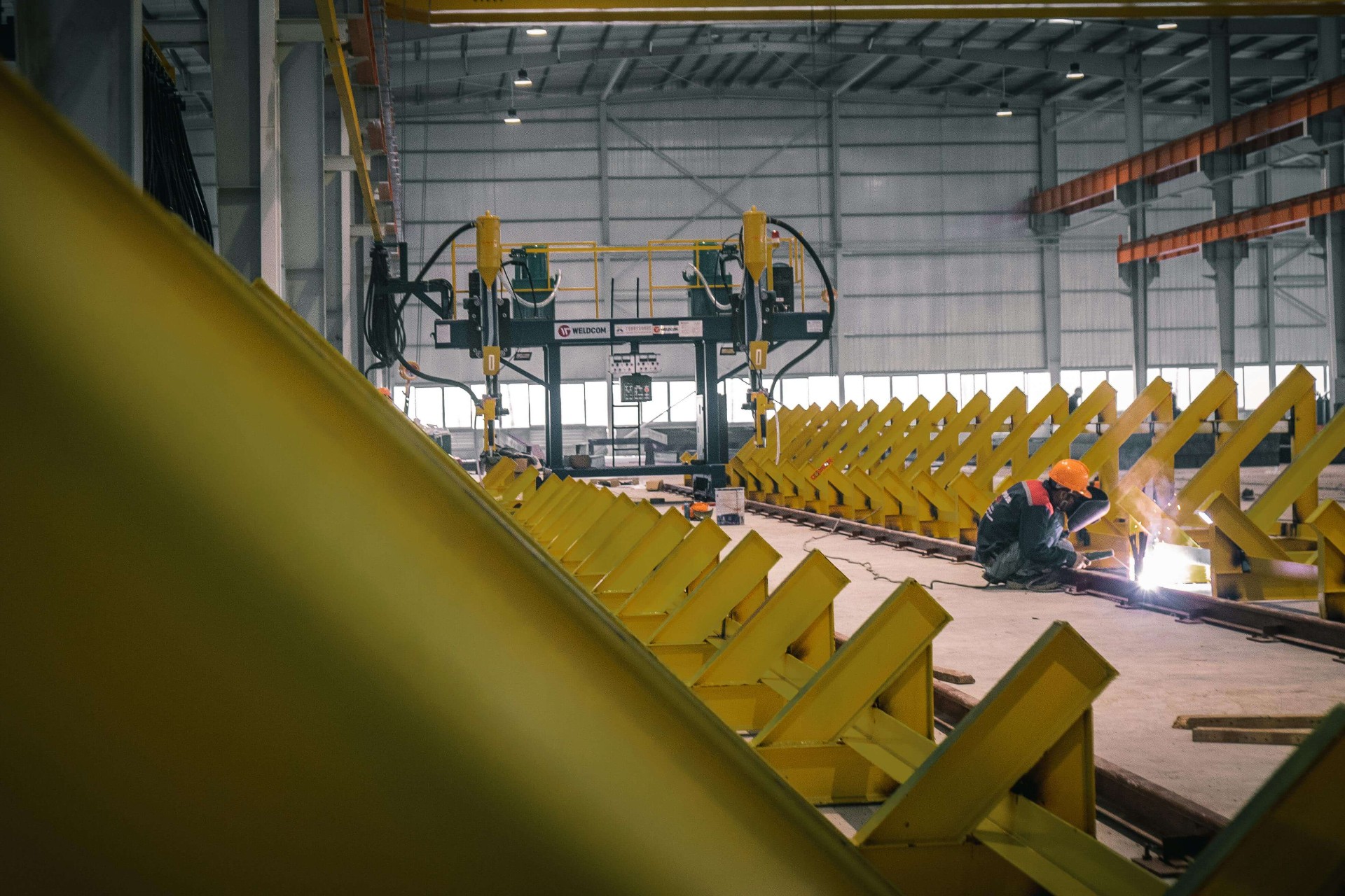 Logistics coordinator reviewing operations on a factory floor with equipment